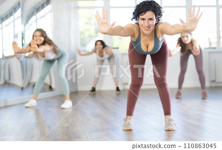 Female teacher conducts modern dance lessons for group of girls 110863045