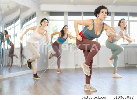Female teacher conducts modern dance lessons for group of girls Female teacher conducts modern dance lessons for group of girls 110863058