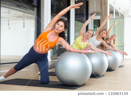 Sporty women doing pilates exercises with fitness ball 110863139