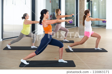Women performing set of exercises with two small pilates balls 110863171