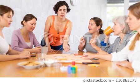 Group of cheerful female colleagues playing board game in office 110863173
