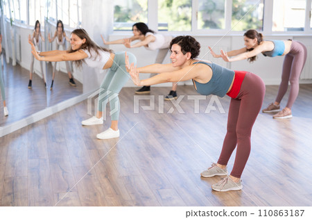 Female teacher conducts modern dance lessons for group of girls 110863187