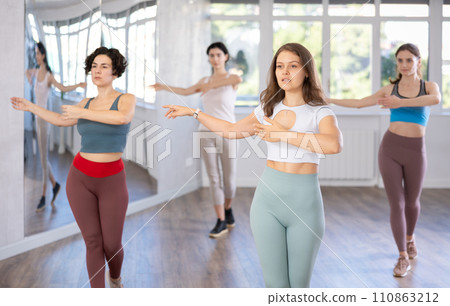 During dance lesson, girls practice and memorize movements to perform slow classical waltz dance. 110863212