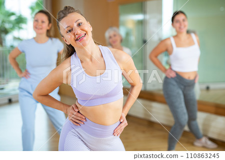 Active middle-aged woman practicing aerobic dance in training hall 110863245