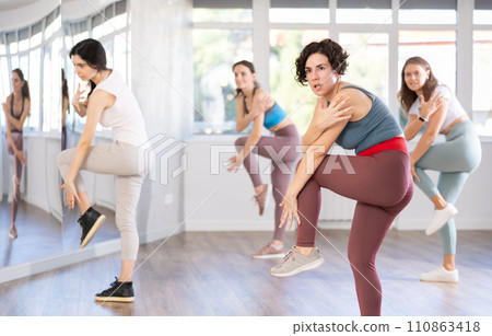 Female teacher conducts modern dance lessons for group of girls 110863418