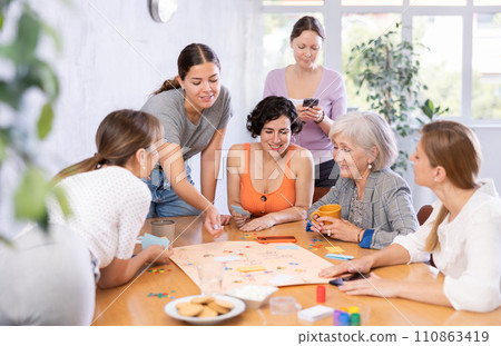 Group of of different years people playing tabletop game 110863419