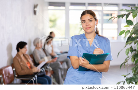 Doctor of clinic in bathrobe is standing in waiting hall and waiting for arrival of patients. Doctor of clinic in bathrobe is standing in waiting hall and waiting for arrival of patients. 110863447