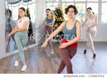 Enthusiastic Hispanic woman leading dance fitness class during Christmas season Enthusiastic Hispanic woman leading dance fitness class during Christmas season 110863452