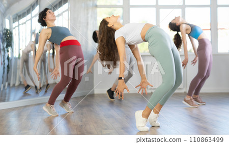 Enthusiastic young girl honing hip-hop moves in dance studio 110863499