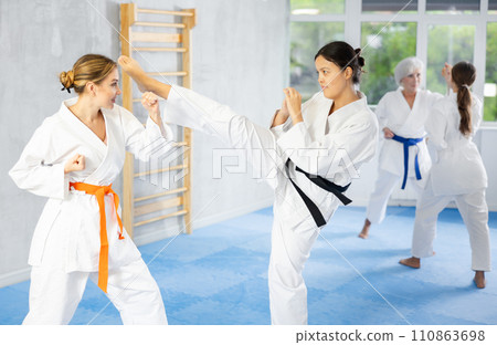 Two young women training karate techniques 110863698