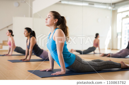 Sporty girl doing stretching asana Urdhva Mukha Shvanasana 110863782