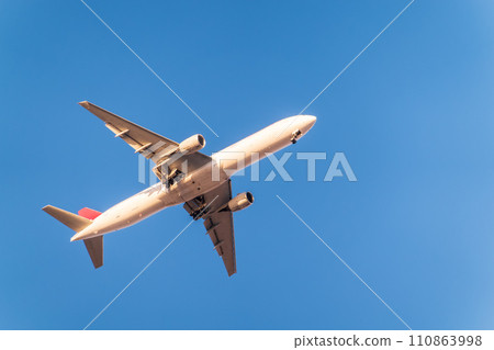 Airplane before landing in blue sky, Airbus A330 110863998