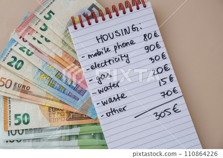 Euro cash money with notebook handwritten housing expenses. Counting bills for electricity, gas, water. Concept of Efficient Consumption and Economy 110864226