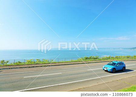 Hokkaido: A car running on the blue sky and the seaside road 110866073