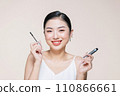 woman hold mascara isolated on beige background 110866661