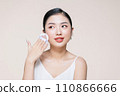asian woman smile looking happy applying makeup with puff makeup to her face 110866666