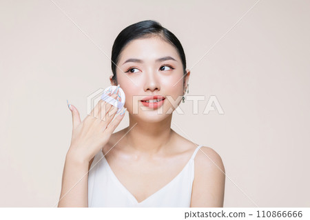 asian woman smile looking happy applying makeup with puff makeup to her face asian woman smile looking happy applying makeup with puff makeup to her face 110866666