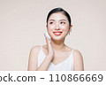 asian woman smile looking happy applying makeup with puff makeup to her face 110866669