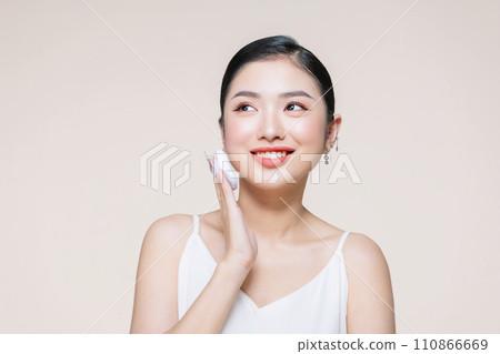 asian woman smile looking happy applying makeup with puff makeup to her face asian woman smile looking happy applying makeup with puff makeup to her face 110866669