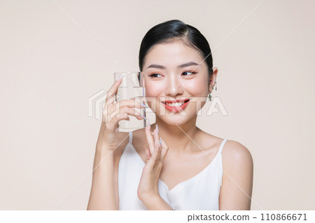 beautiful young asian woman with closed eyes holding glass of clear water near face beautiful young asian woman with closed eyes holding glass of clear water near face 110866671