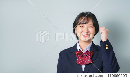 A female student wearing a uniform doing a fist pump A female student wearing a uniform doing a fist pump 110866905