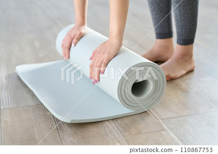 Hands of a woman spreading out a yoga mat 110867753