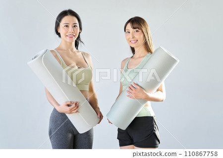 two women with yoga mats two women with yoga mats 110867758