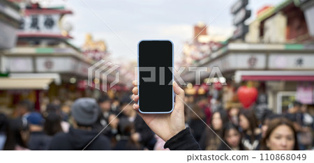 擁擠的旅遊勝地和手持智慧型手機 110868049