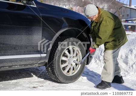 A man tightens a tire nut with a torque wrench 110869772