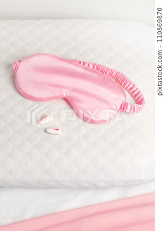 Silk sleep mask, earplugs, orthopedic pillow. All conditions for good deep sleep. close up in bed Silk sleep mask, earplugs, orthopedic pillow. All conditions for good deep sleep. close up in bed 110869870