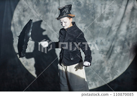 Waist up portrait of classic mime performer acting on stage in spotlight with umbrella, copy space Waist up portrait of classic mime performer acting on stage in spotlight with umbrella, copy space 110870085