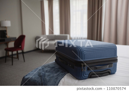 Close up background image of blue plastic suitcase on bed in modern hotel room, copy space Close up background image of blue plastic suitcase on bed in modern hotel room, copy space 110870574