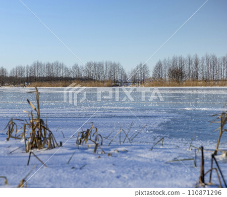 frozen lake covered with snow and ice in winter frozen lake covered with snow and ice in winter 110871296