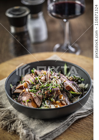 Roast beef salad with herbs and balsamic sauce in the style of a bowl on a restaurant table 110871324