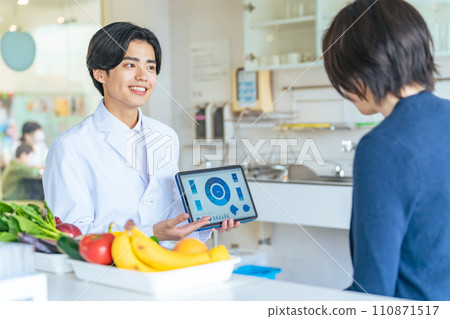 A man in a white coat showing a tablet screen and explaining A man in a white coat showing a tablet screen and explaining 110871517