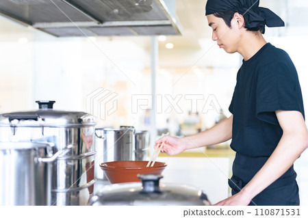 A ramen shop clerk serving ramen in a bowl A ramen shop clerk serving ramen in a bowl 110871531