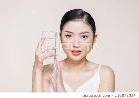 beautiful young asian woman holding glass of clear water near face beautiful young asian woman holding glass of clear water near face 110872034
