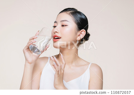 beautiful girl drinking water from transparent glass isolated on white beautiful girl drinking water from transparent glass isolated on white 110872037