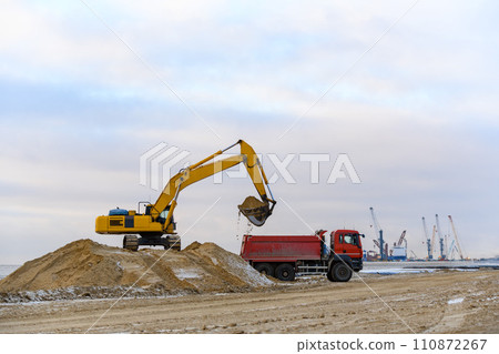 Yellow excavator working on construction site. The road construction. 110872267