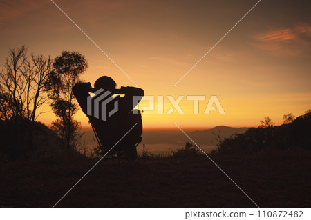 landscape and travel concept with solo freelancer man sit on chair and see sunrise with layer of mountain background landscape and travel concept with solo freelancer man sit on chair and see sunrise with layer of mountain background 110872482