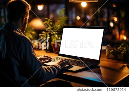 Man works at home in the evening with a laptop, a view from the back 110872954