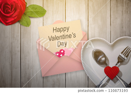 Heart plate with silverware of spoon and fork with a red heart and valentine letter with rose flowerhead 110873193
