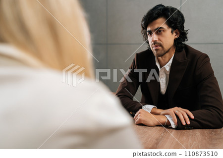 Back view of unrecognizable businesswoman having meeting with serious male colleague in office. Concept of company CEO negotiating with business partners, involved in dispute at briefing. Back view of unrecognizable businesswoman having meeting with serious male colleague in office. Concept of company CEO negotiating with business partners, involved in dispute at briefing. 110873510