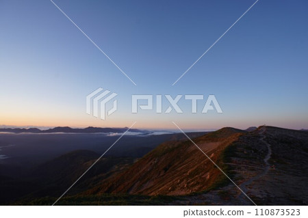 Mountain trail illuminated by the morning sun 110873523