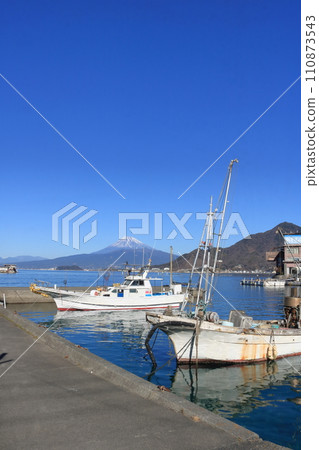 早春白雪皚皚的富士山和停泊在漁港的漁船 110873543