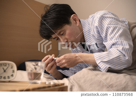 Man taking medicine before bed, insomnia, sleeping pills 110873568