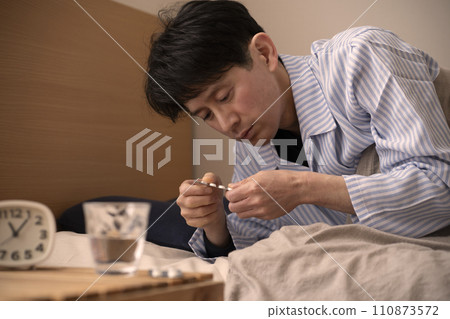 Man taking medicine before bed, insomnia, sleeping pills 110873572