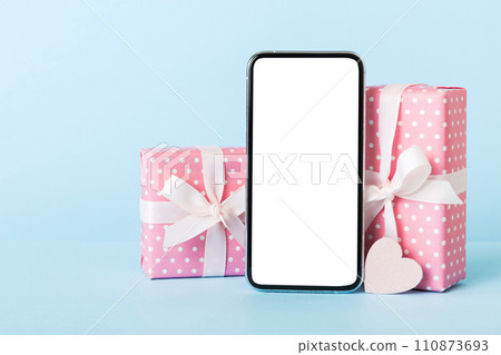 mobile phone with blank screen on colored background with hearts, calendar and gift box, valentine day concept perspertive view flat lay mobile phone with blank screen on colored background with hearts, calendar and gift box, valentine day concept perspertive view flat lay 110873693