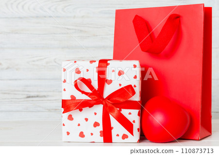 Shopping bag with gift box on colored background perspecrive view. Space for text holiday concept Shopping bag with gift box on colored background perspecrive view. Space for text holiday concept 110873713
