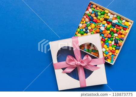 Box with sweet chocolate candies on color background, Various candy sweets. Valentines day gift box. Top view flat lay with copy space 110873775